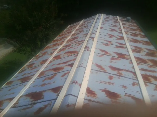 Rusted metal roof panels with new wood purlins before replacement — Storm Damage Roof Repair in Justin by Roofing Brothers
