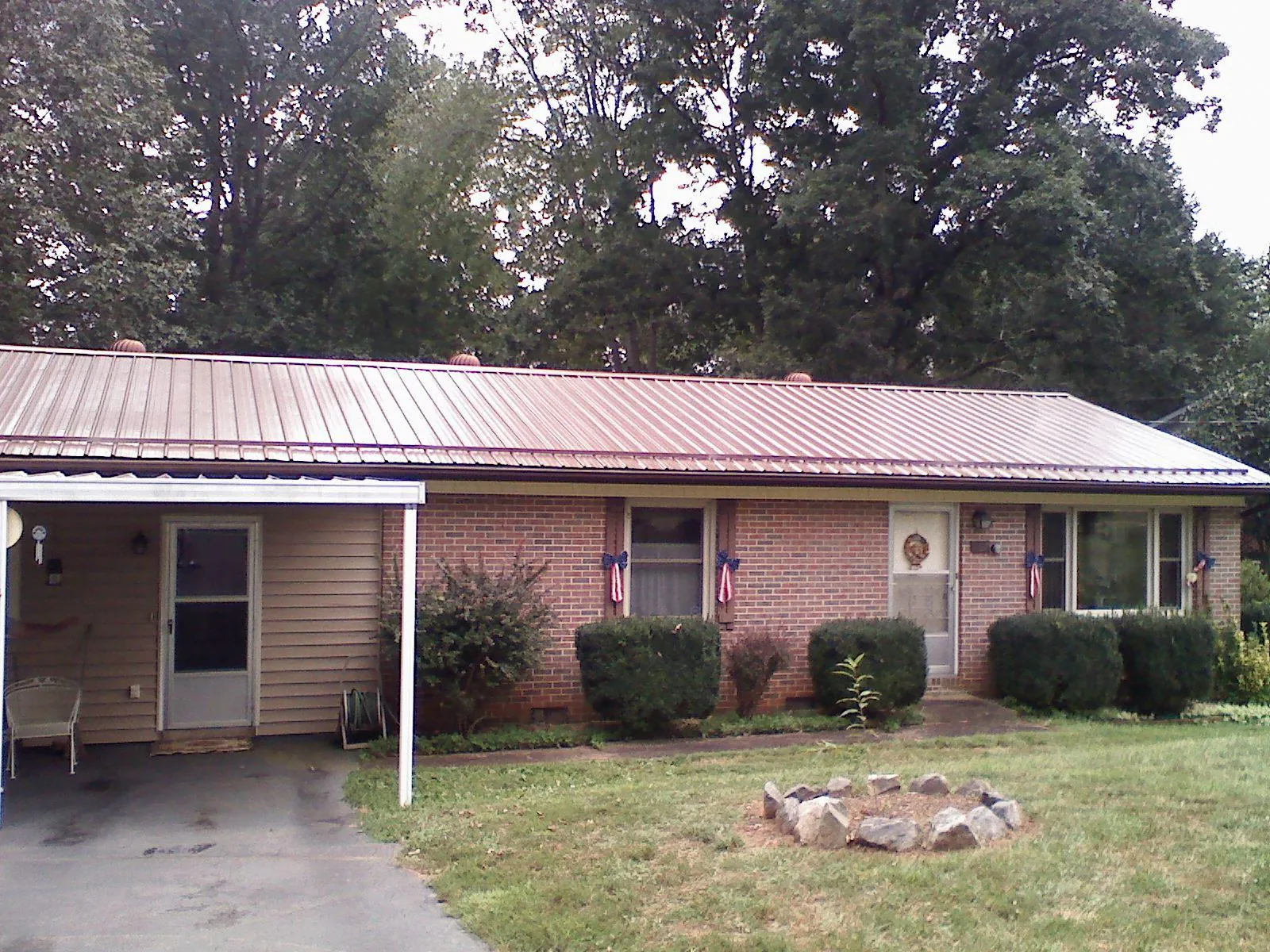 Bronze metal roof and carport on a brick ranch home — Roof Repair work by our crew in Justin